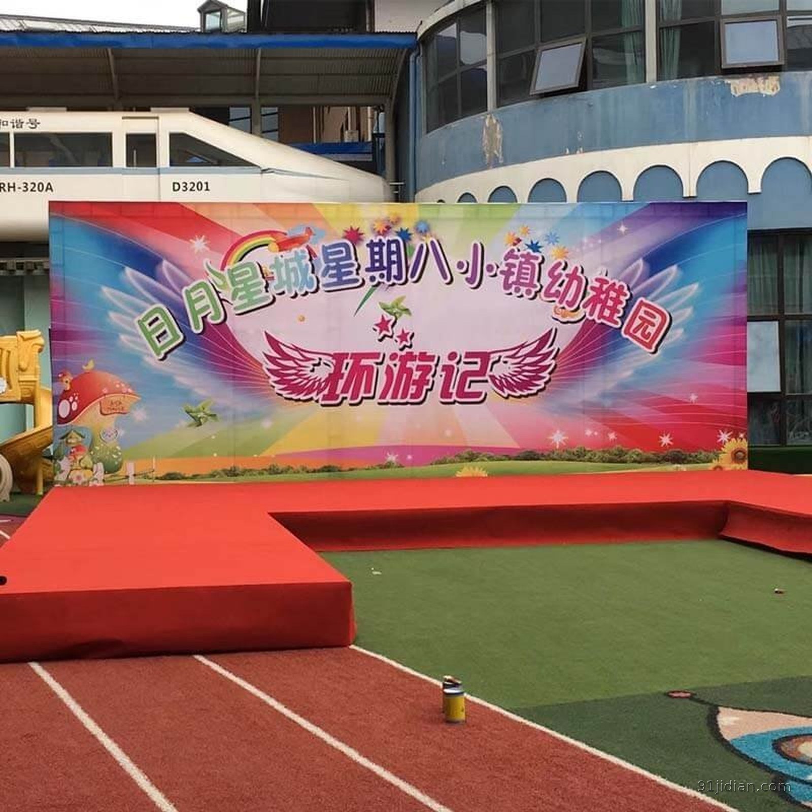 青岛会议背景板实拍：活动现场整面喷绘背景墙配红地毯舞台，属临时搭建年会背景而非前台永久LOGO金属墙