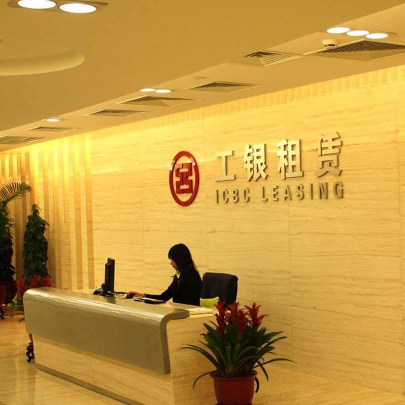 青岛公司形象墙实拍：接待前台后方固定安装立体金属LOGO与公司名，属长期形象墙而非活动临时喷绘背景