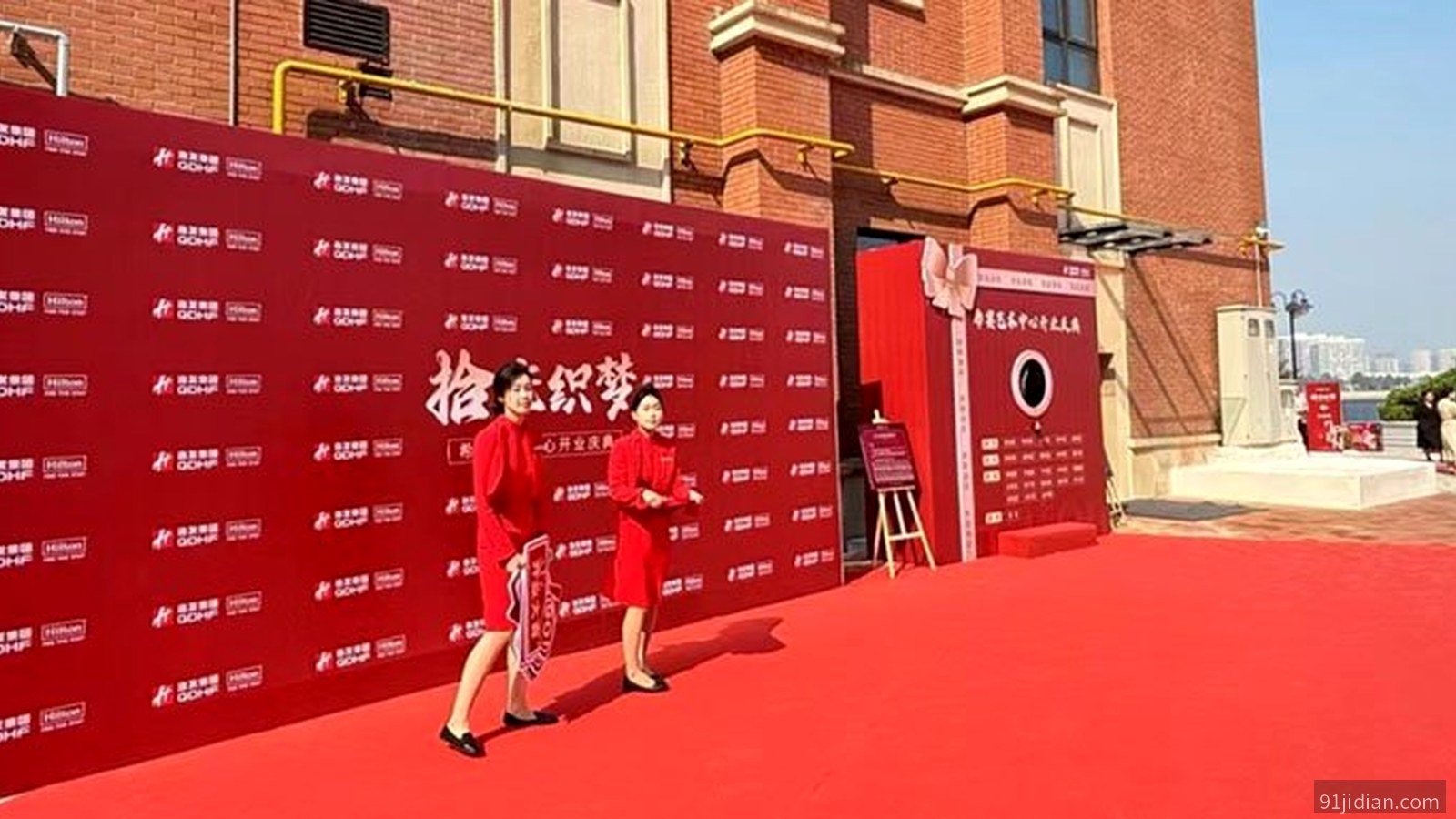 开业仪式现场组合布置：红色背景墙+礼盒道具+红地毯