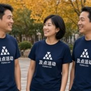 青岛文化衫印字示意：三人穿藏青色短袖文化衫，胸前印有及点活动抽象标识，秋季户外团建场景
